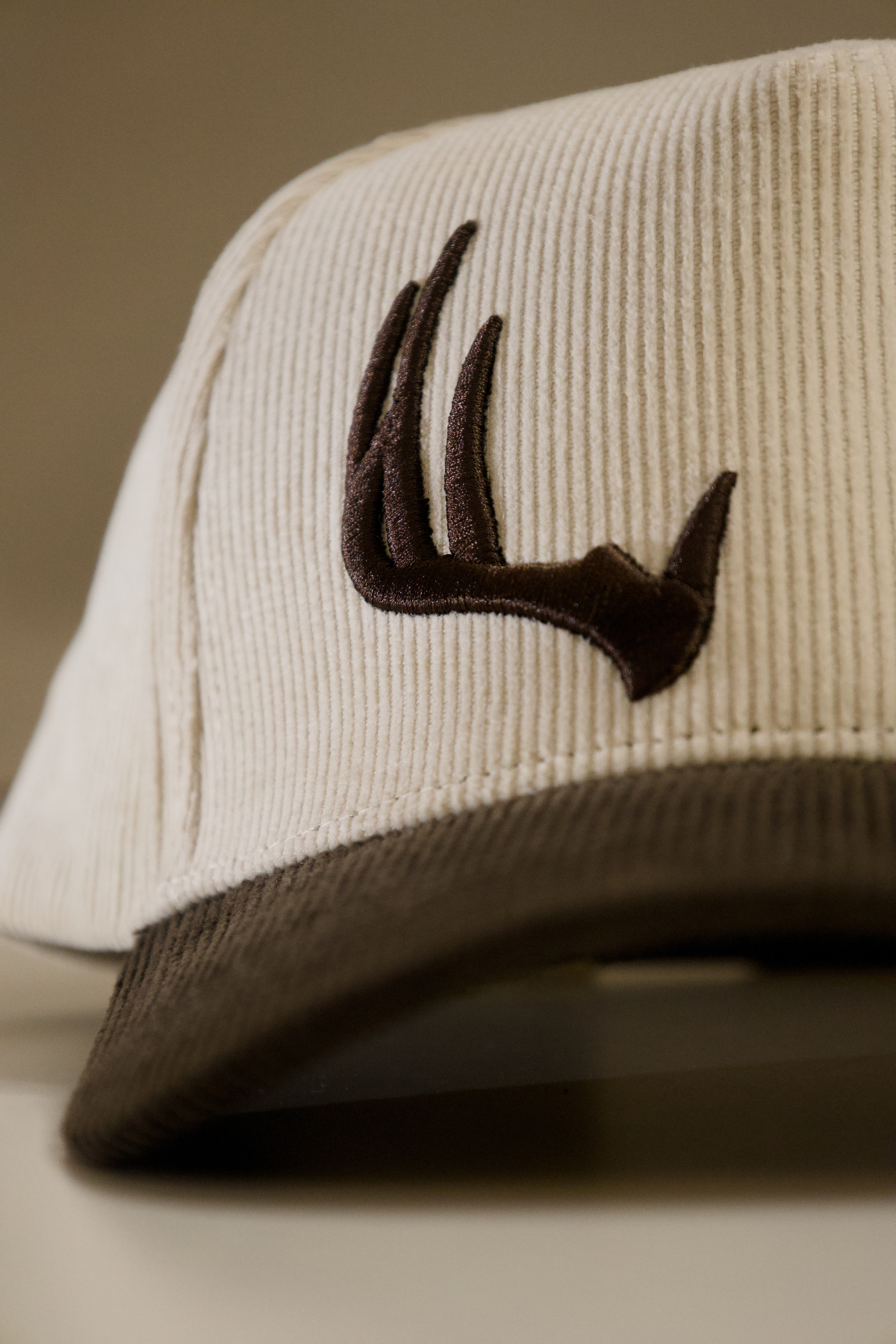 Cream corduroy snapback hat with dark brown embroidered logo and brown brim from the Sunday Oatmeal brand
